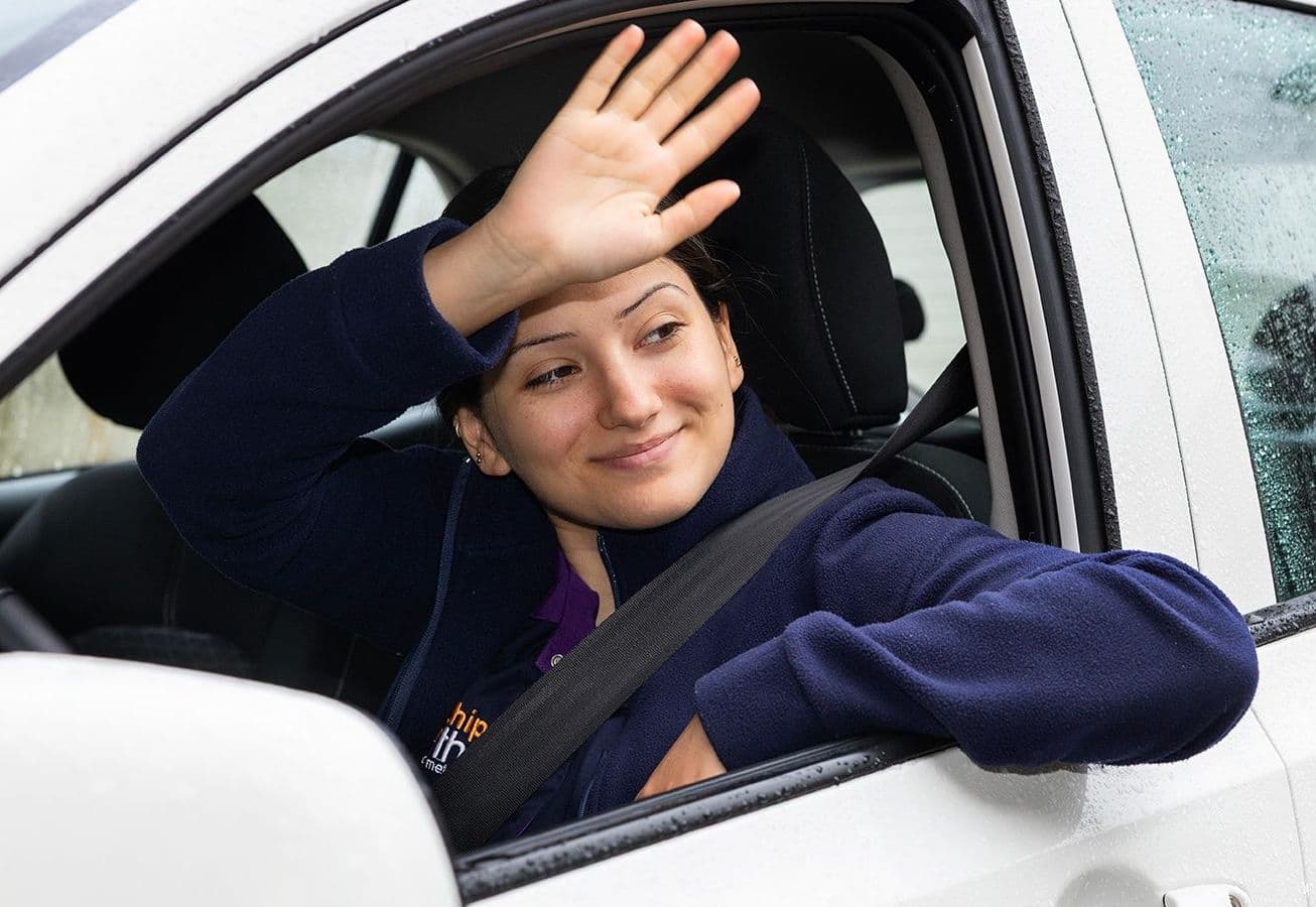 Thuiszorg - wijkverpleegkundige - Özlem zwaait vanuit auto